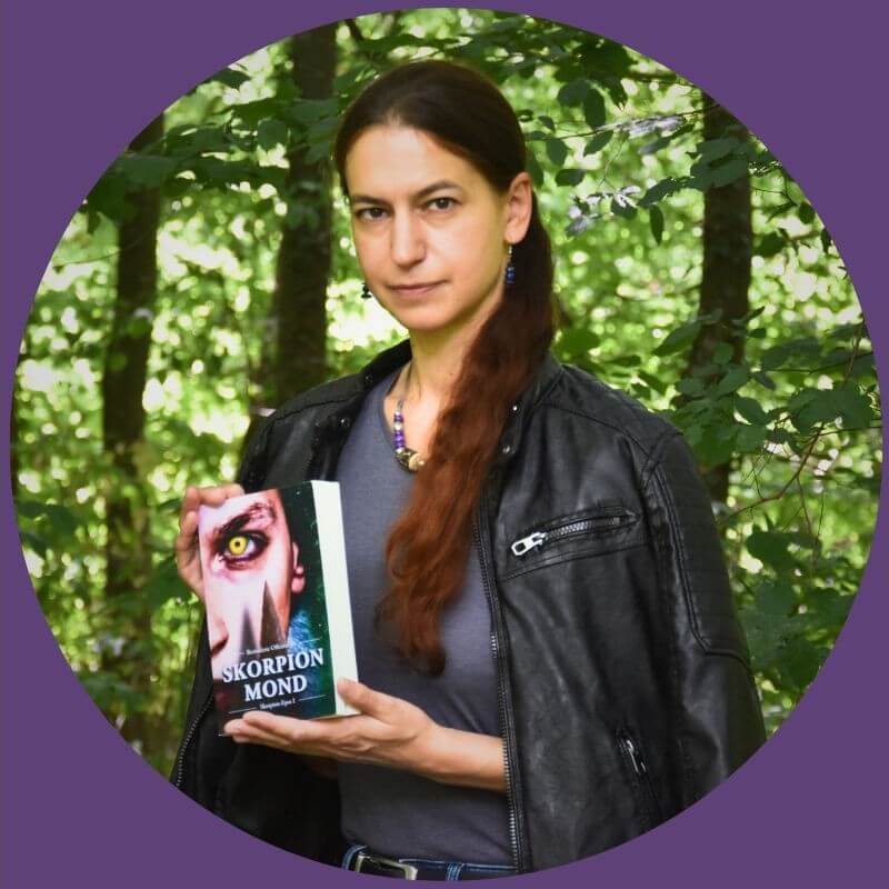 Autorin mit Fantasy-Buch im Wald.