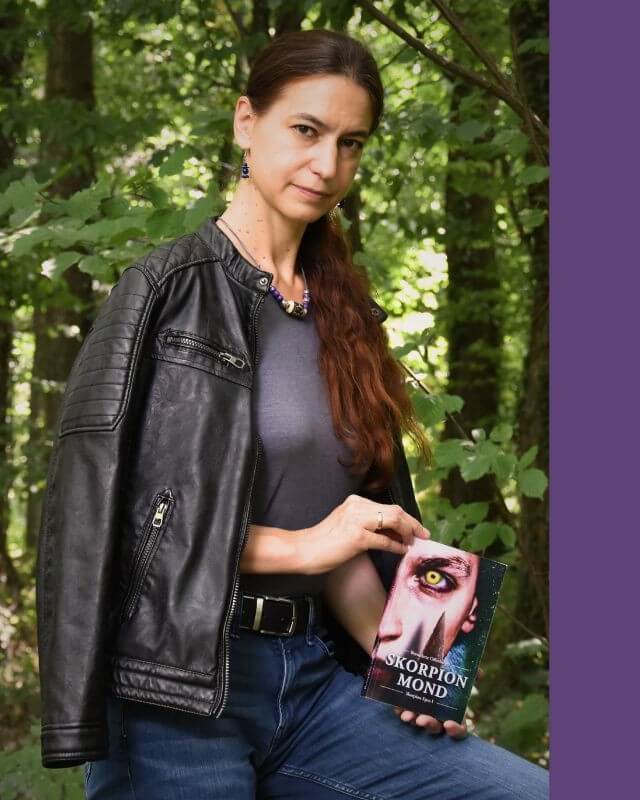 Fantasy-Autorin mit einem ihrer Bücher in der Hand.